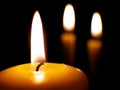 Yellow burning candles on dark background