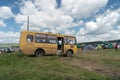 Yellow bus with the inscription on the side -Children - brought children to the music festival and stands against the tents