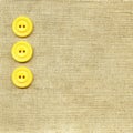 Yellow buttons on beige fabric Royalty Free Stock Photo