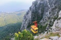 The yellow cab of the funicular with people inside climbs the Ai Petri mountain in the Crimea. Top-down view of the mountains,