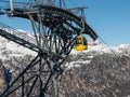 Yellow cable car ski lift going up on the mountain top Royalty Free Stock Photo