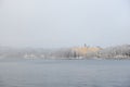 Yellow Campus Manilla school building in snow covered Stockholm island of DjurgÃ¥rden in winter fog Royalty Free Stock Photo