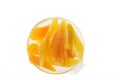 Yellow candied melon slices in a glass vase on a white background, top view in a glass vase on a white background, top view