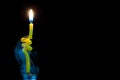 Yellow candle in a broken light bulb. Royalty Free Stock Photo