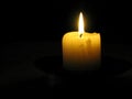 Yellow candle in a dark room Royalty Free Stock Photo