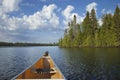 A yellow canoe moves on a northern Minnesota lake on a sunny summer morning Royalty Free Stock Photo