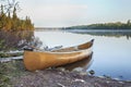 Yellow canoe on shore of northern Minnesota lake in early morning light Royalty Free Stock Photo