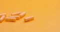 Yellow capsule pills on yellow background with copy space. Pharmacy and health insurance concept. Prescription drugs.