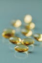 Yellow capsule with vitamin E tocopherol on blue surface Royalty Free Stock Photo