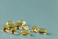 Yellow capsule with vitamin E tocopherol on blue surface Royalty Free Stock Photo