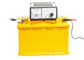 yellow car battery with car battery charger isolated on white background Royalty Free Stock Photo