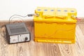 yellow car battery with car battery charger Royalty Free Stock Photo