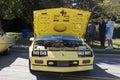 A yellow car at an outdoor car show