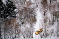 Yellow car stands among snow-covered trees in a winter Park top view of a Yandex taxi in the woods - Moscow Russia 04 December