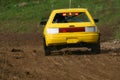 Yellow car on track going fast and throwing dirt in the air Royalty Free Stock Photo