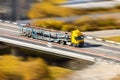 Yellow car transporter moving fast at the bridge Royalty Free Stock Photo