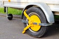 Yellow car wheel lock on a car trailer