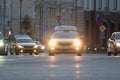 Yellow car of Yandex taxi service moving alone road in city downtown
