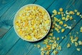 Yellow caramelized popcorn on a blue wooden background.  Fast food, junk food. Royalty Free Stock Photo