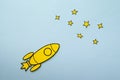 Yellow cartoon rocket flying through space with copy space