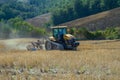 Yellow caterpillar tractor with a plow on a mowed field