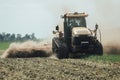 Yellow caterpillar tractor in summer in a field during a test drive for plowing a land