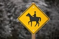 Yellow Caution Horse Riding Sign in a Rural Setting in Winter Isolated against a Snowy Forest Royalty Free Stock Photo