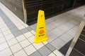 Yellow caution slippery wet floor sign labeled in English and Fr Royalty Free Stock Photo