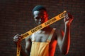 Yellow caution tape and uniform. Futuristic neon lighting. Young african american man in the studio Royalty Free Stock Photo