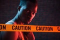 Yellow caution tape and uniform. Futuristic neon lighting. Young african american man in the studio Royalty Free Stock Photo