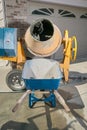 Yellow cement mixer machine and wheelbarrow Royalty Free Stock Photo