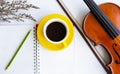 The yellow ceramic coffee cup and pencil put on opened book,beside dried flower and classic violin with bow Royalty Free Stock Photo