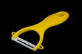 Yellow ceramic peeler for fruits and vegetables isolated on black