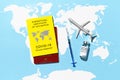 Yellow Certificate of Vaccination, syringe, vial with vaccine, and toy plane on world map background