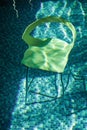 Yellow chair underwater. Turquoise ceramic tiles in the pool. Depression concept. Lifelessness and clothedness Royalty Free Stock Photo