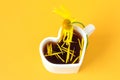 Yellow chamomile, bent over a cup of tea in the shape of a heart, petals in it, yellow background, place for text-the concept of