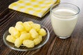 Yellow napkin, sweet corn sticks in transparent saucer, glass of milk on wooden table Royalty Free Stock Photo