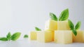 Yellow Cheese Cubes with Fresh Green Basil Leaves on White Background Royalty Free Stock Photo