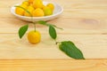 Yellow cherry plum against of saucer with other cherry plums