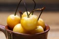 Yellow cherry in a rustic style on a wooden background. Berries of ripe fresh cherries in a cup. Royalty Free Stock Photo