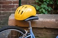 yellow childs bike helmet resting on a cargo bike seat Royalty Free Stock Photo