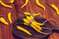 Yellow chilli peppers tied with thread and  lies on a dark wooden board, concept of harvesting peppers for the winter, healthy eat Royalty Free Stock Photo