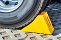 Yellow chock at the wheel of a parked truck Royalty Free Stock Photo
