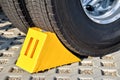 Yellow chock at the wheel of a parked truck Royalty Free Stock Photo