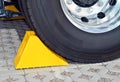 Yellow chock at the wheel of a parked truck Royalty Free Stock Photo