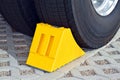 Yellow chock at the wheel of a parked truck Royalty Free Stock Photo