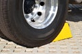 Yellow chock at the wheel of a parked truck Royalty Free Stock Photo