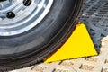 Yellow chock at the wheel of a parked truck