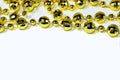 Yellow Christmas tree beads close up on the top edge on a white background with a copy space Royalty Free Stock Photo