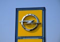 Yellow and chrome color OPEL logo on street sign. blue sky background. Royalty Free Stock Photo